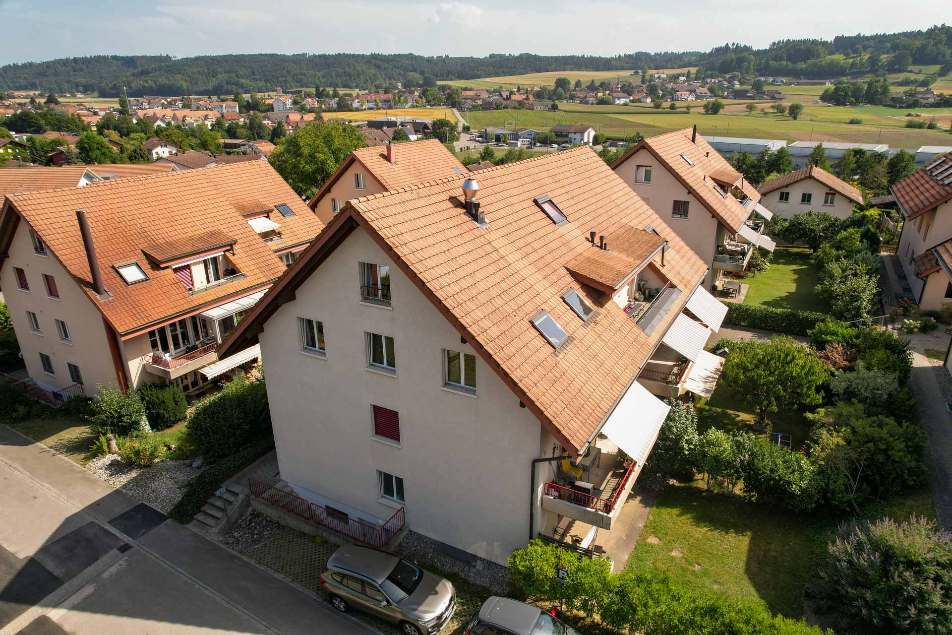 Luftaufnahme des Mehrfamilienhauses mit der Dachwohnung in Schüpfen