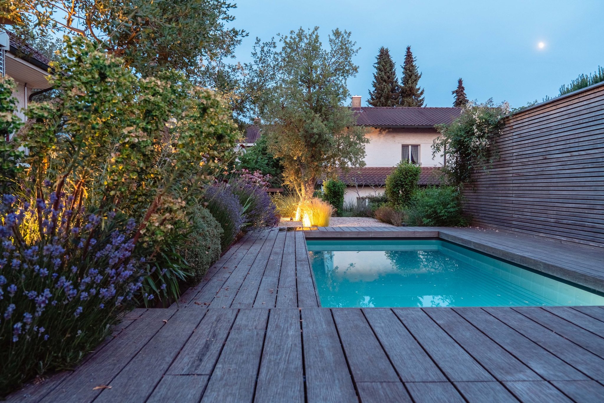 Gartenanlage mit Salzwasserpool des Einfamilienhauses in Jegenstorf am Abend